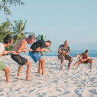 An outdoor corporate event with attendees engaging in a spirited game of tug-of-war.