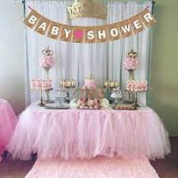 A beautifully decorated table at a baby shower, adorned with cakes and a ribbon that reads 'Baby Shower.
